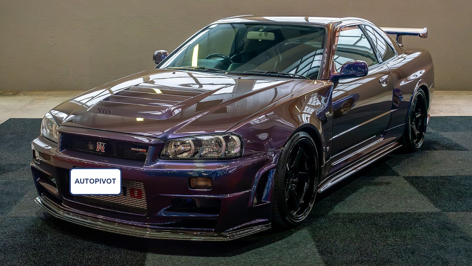 Midnight purple Nissan Skyline GT-R R34 on a showroom floor